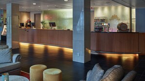 A lobby with a reception desk, seating area, and a bar.