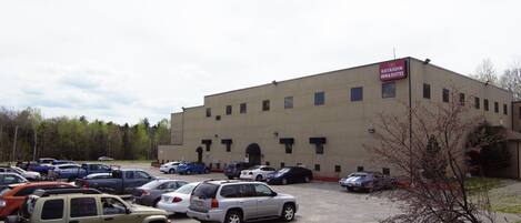 A parking lot with various cars and a building labeled "Katahdin Inn & Suites".
