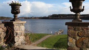 Un pont de pierre enjambe un lac paisible, et au loin, on aperçoit une ville et une église.