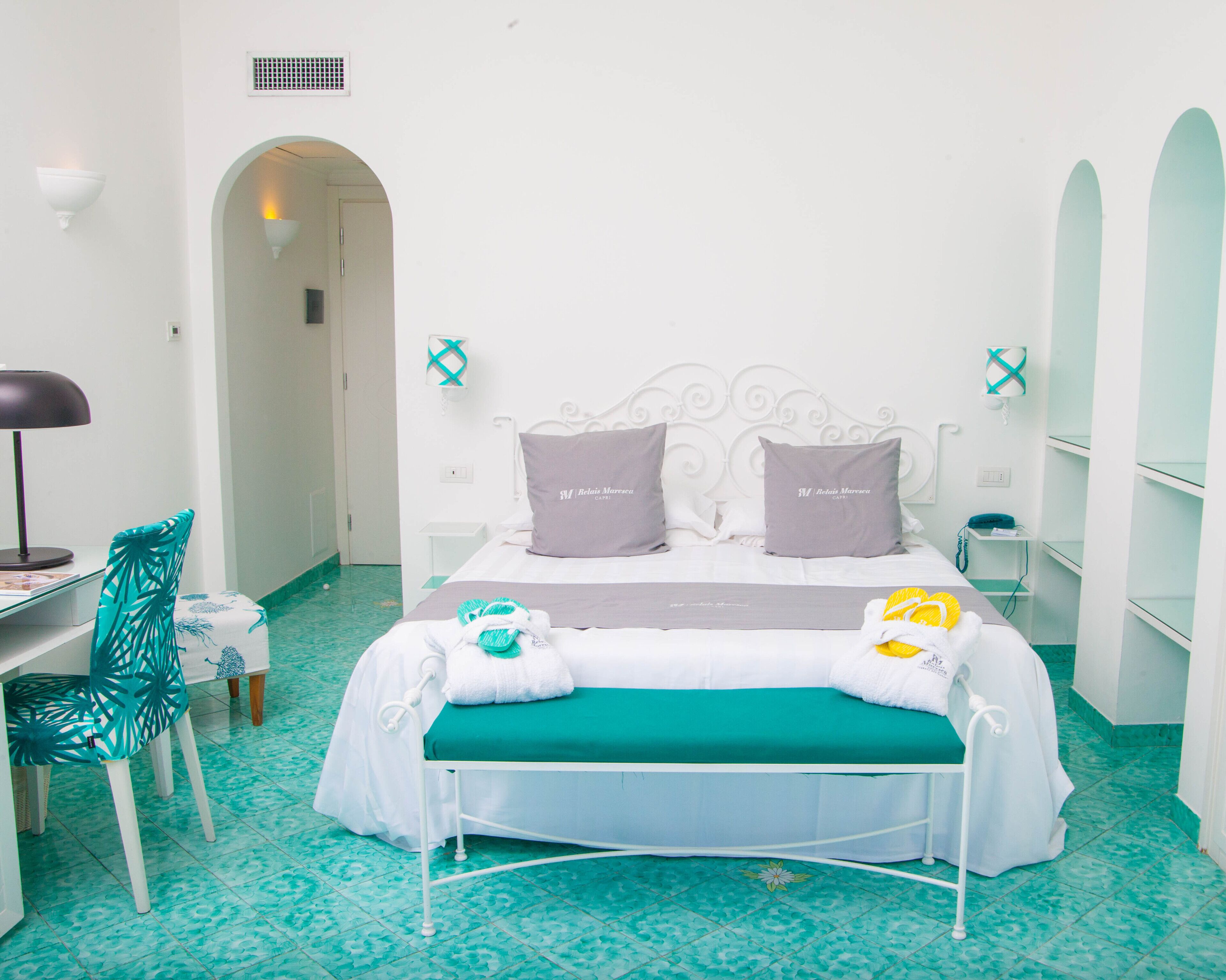 A hotel room with a bed, a desk, and a chair.