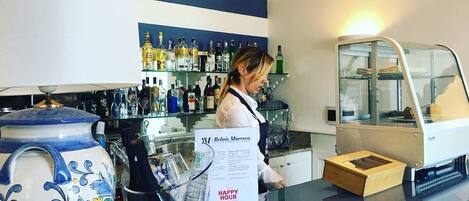 A bar area with a counter, a menu stand, and a display case with bottles.