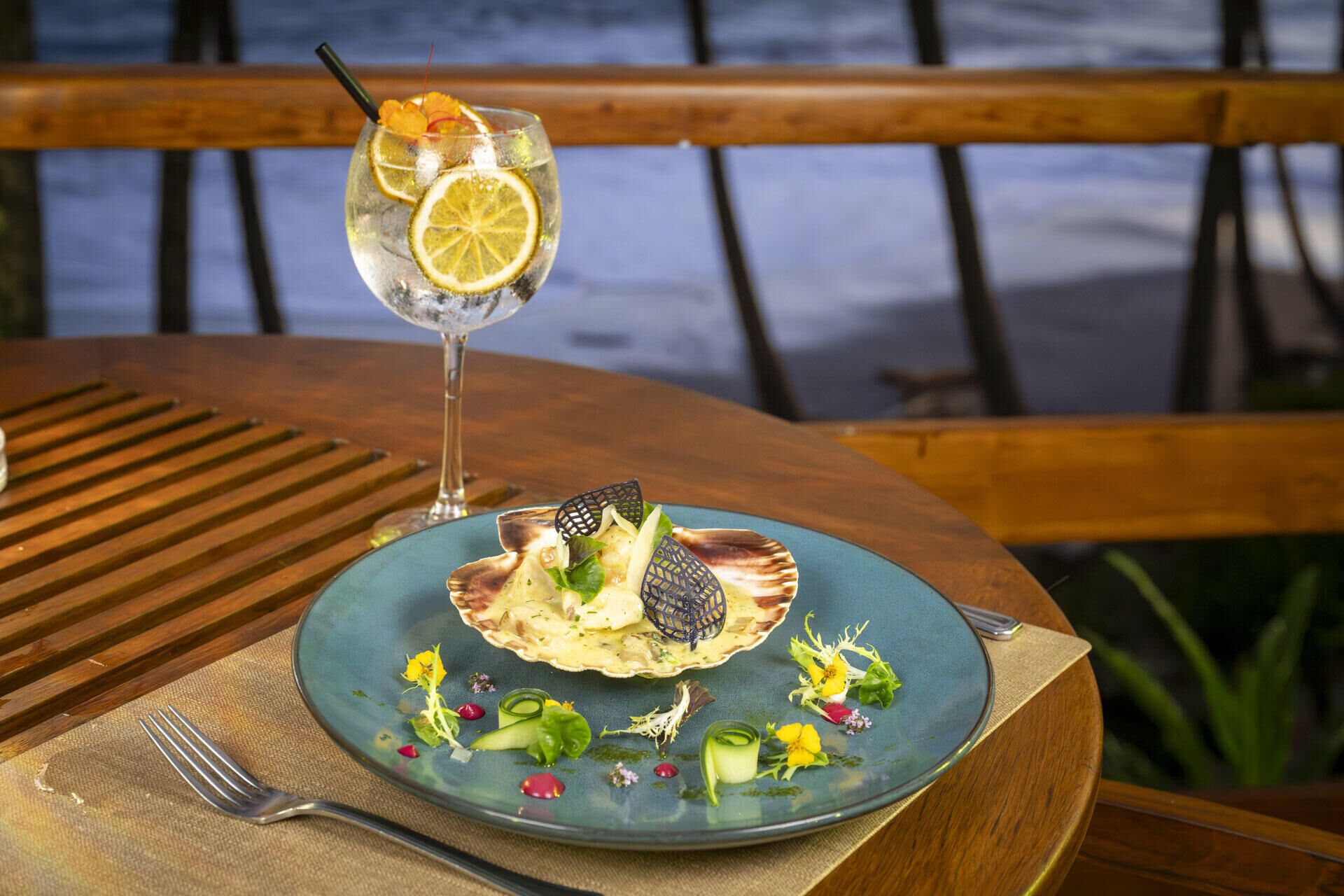 A table with a plate of food and a glass of drink.