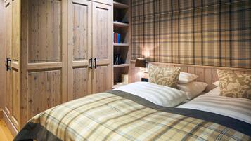Ein Schlafzimmer mit Bett, Kleiderschrank und einem Regal mit Büchern.
