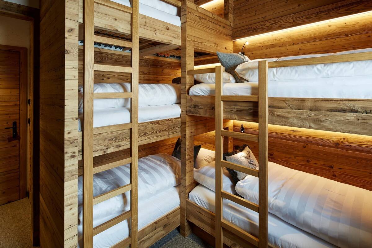 Ein Zimmer mit Holzkaryaten und mehreren Betten sowie einer Himmellaenge.