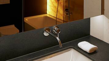 Une salle de bain moderne avec un grand miroir, deux lavabos et une douche.
