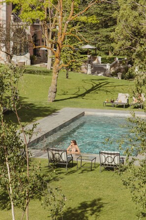 Piscine extérieure en saison, chaises longues