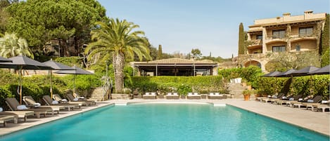 Een binnenzwembad, een buitenzwembad en parasols bij het zwembad