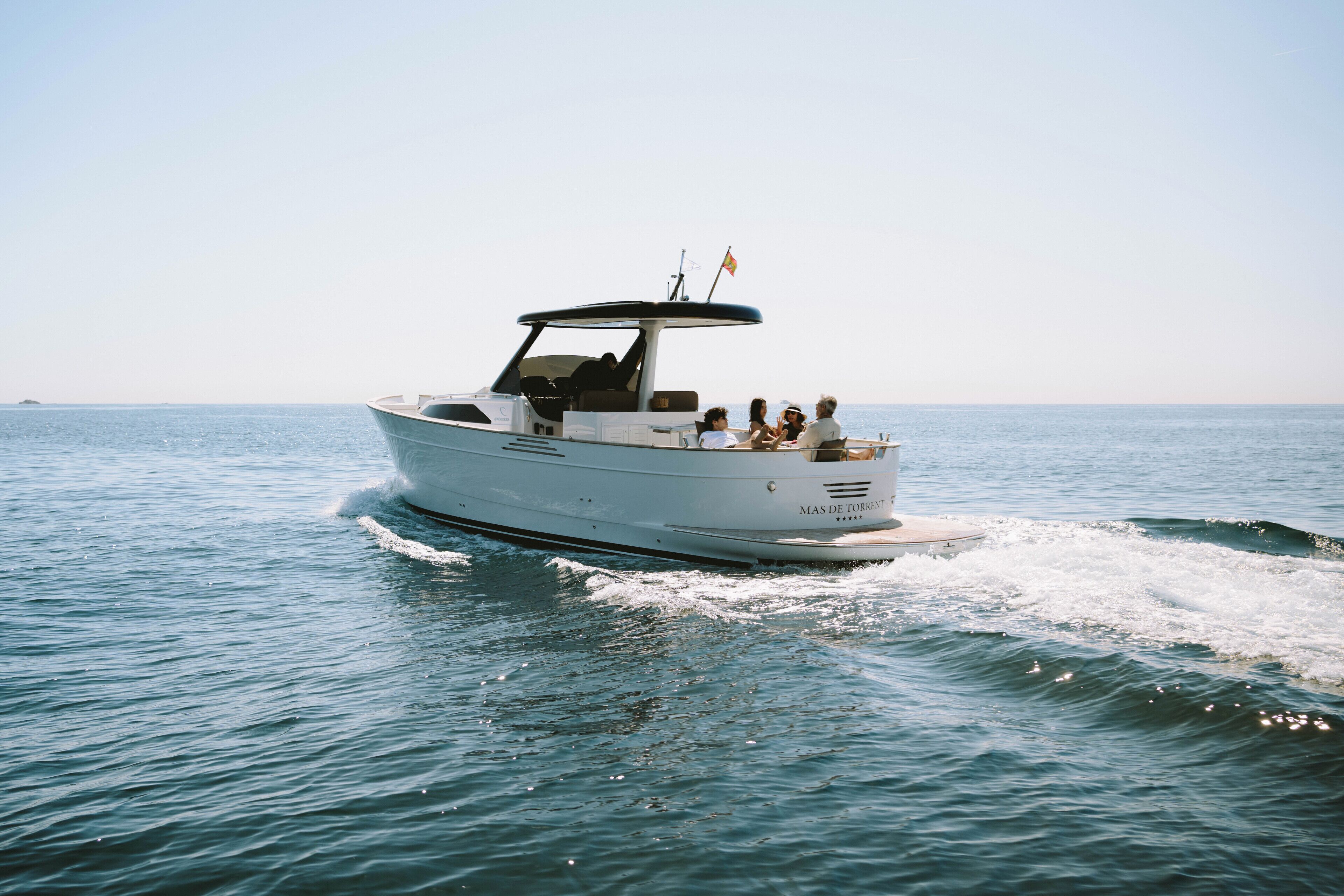 A white motorboat with a canopy, moving on calm water.