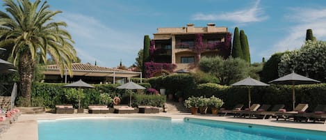 Een binnenzwembad, een buitenzwembad en parasols bij het zwembad