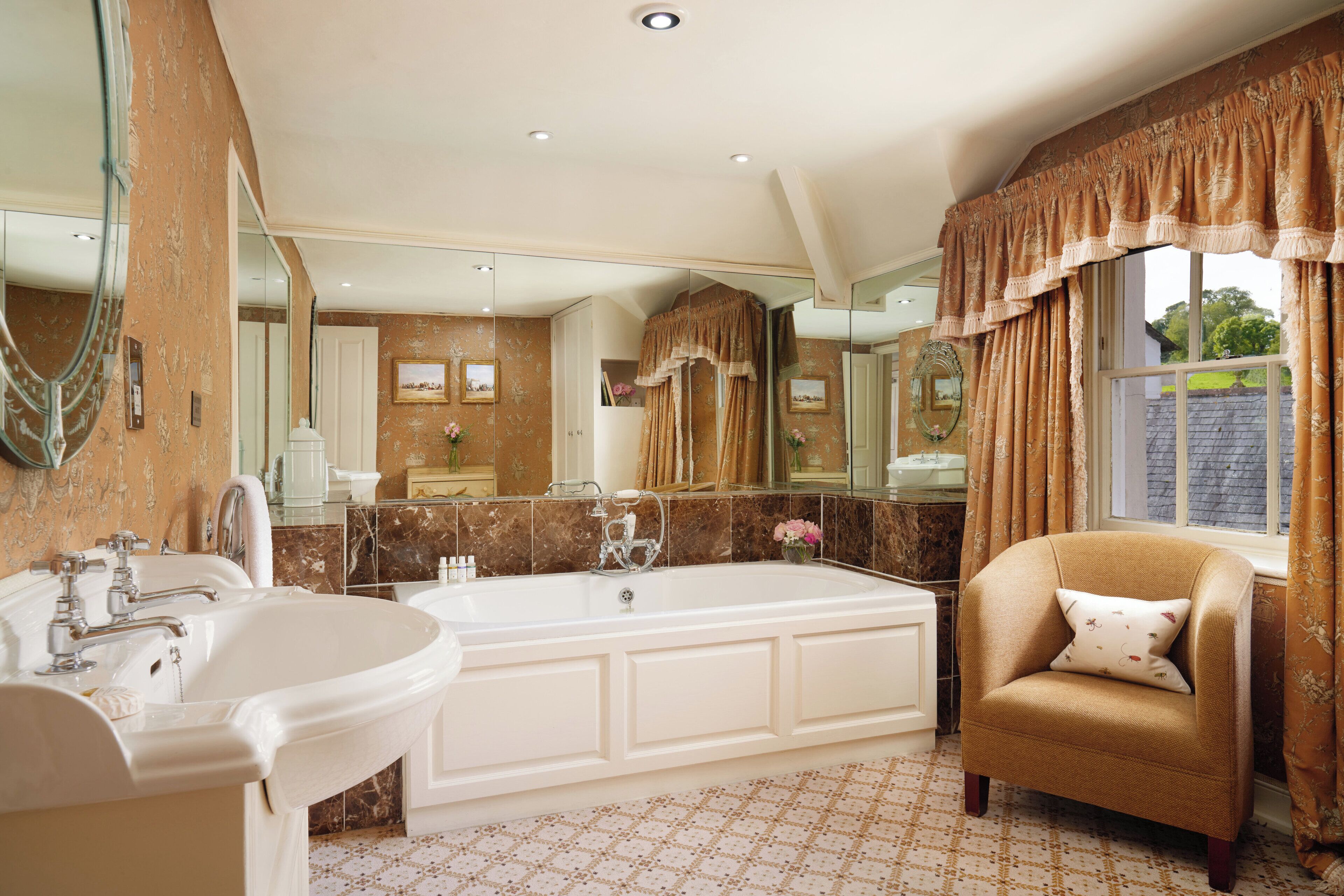 A spacious bathroom with a large bathtub, a separate sink, and a vanity.