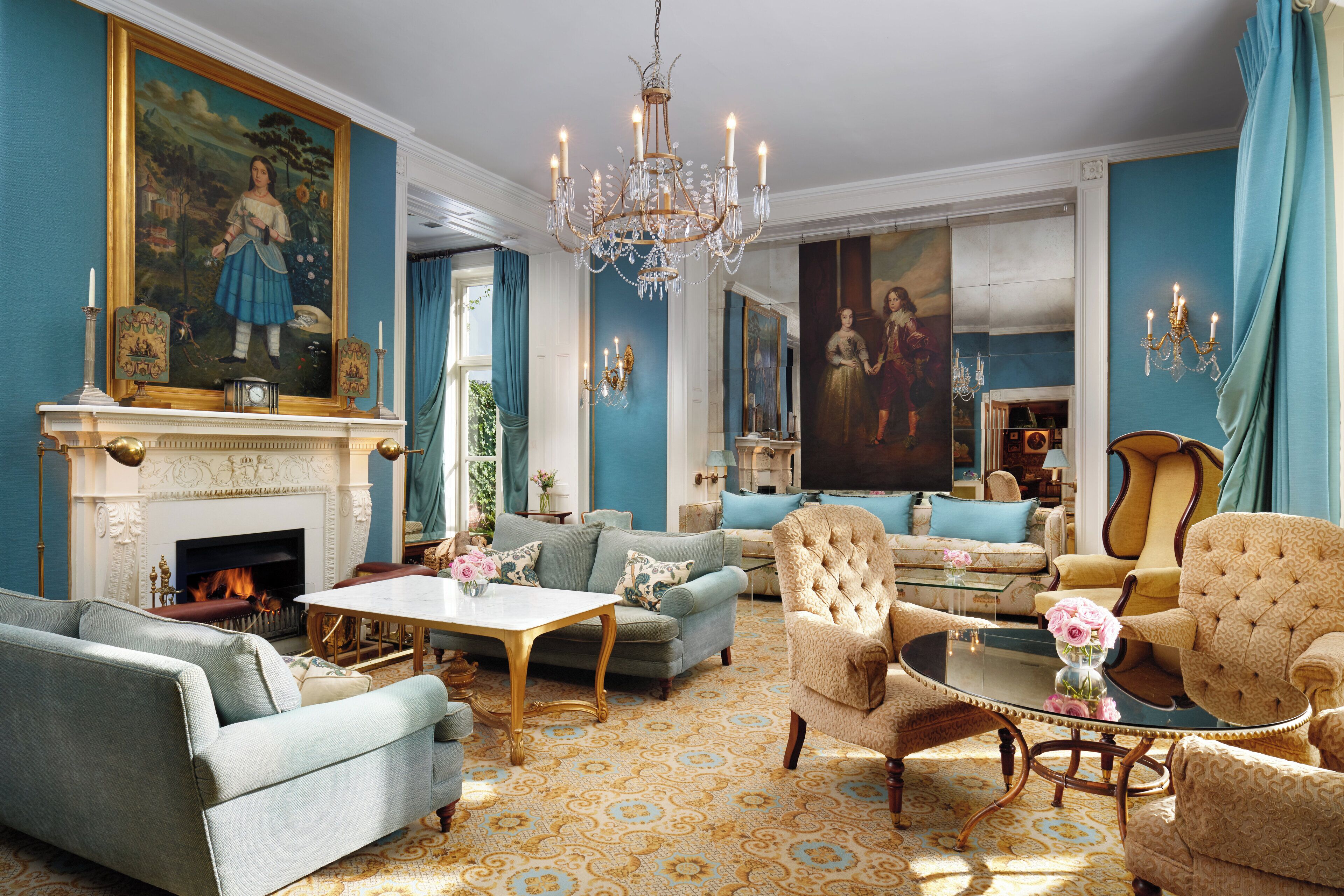 A spacious living room with a fireplace, comfortable seating, and a large painting.