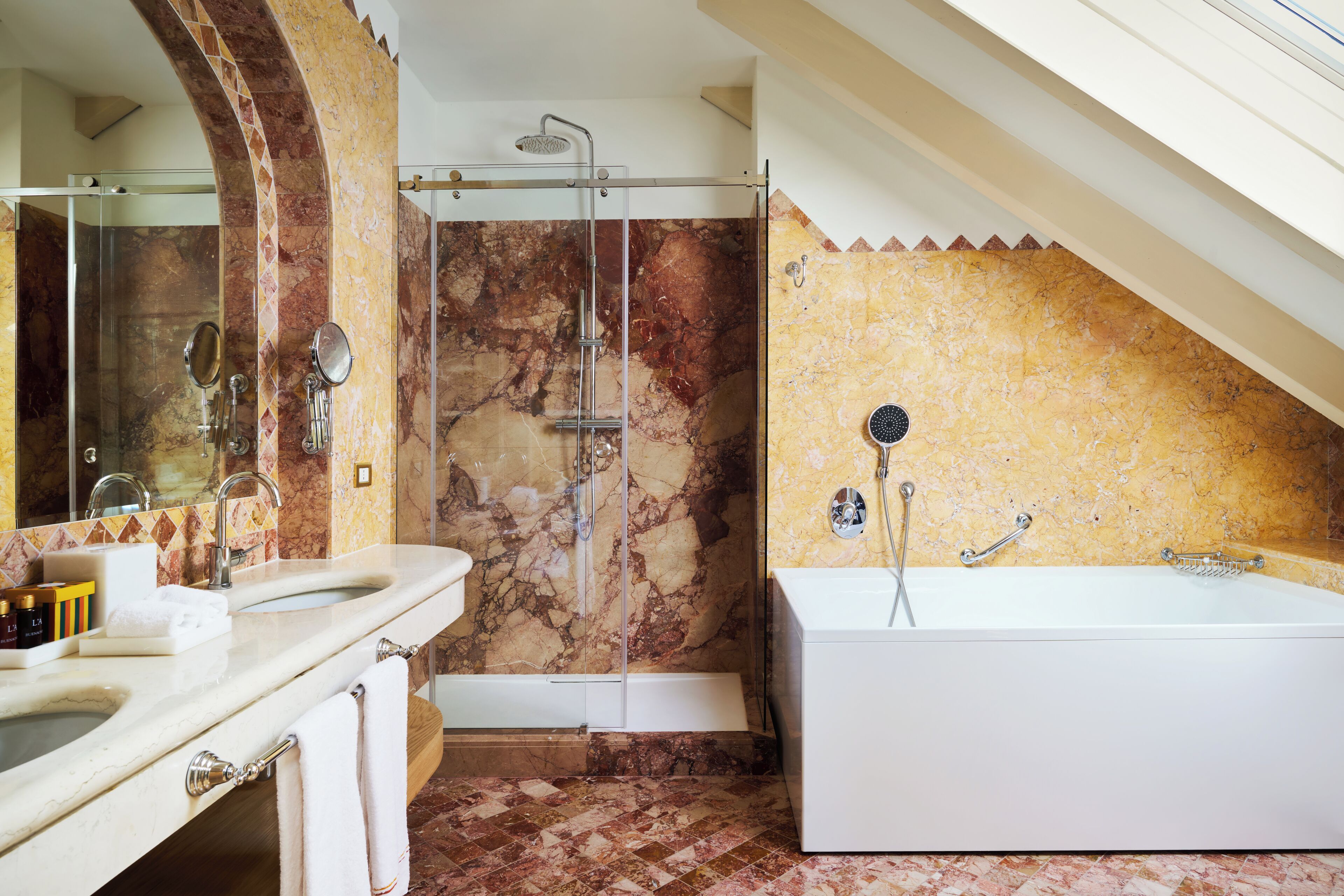 Een moderne badkamer met een marmeren douche, een ruim bad en een wastafel met spiegel.