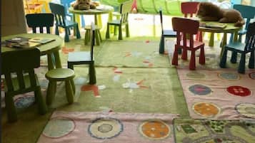 Relax in a bright, inviting room with a large window and colorful rug, perfect for families to play and unwind.