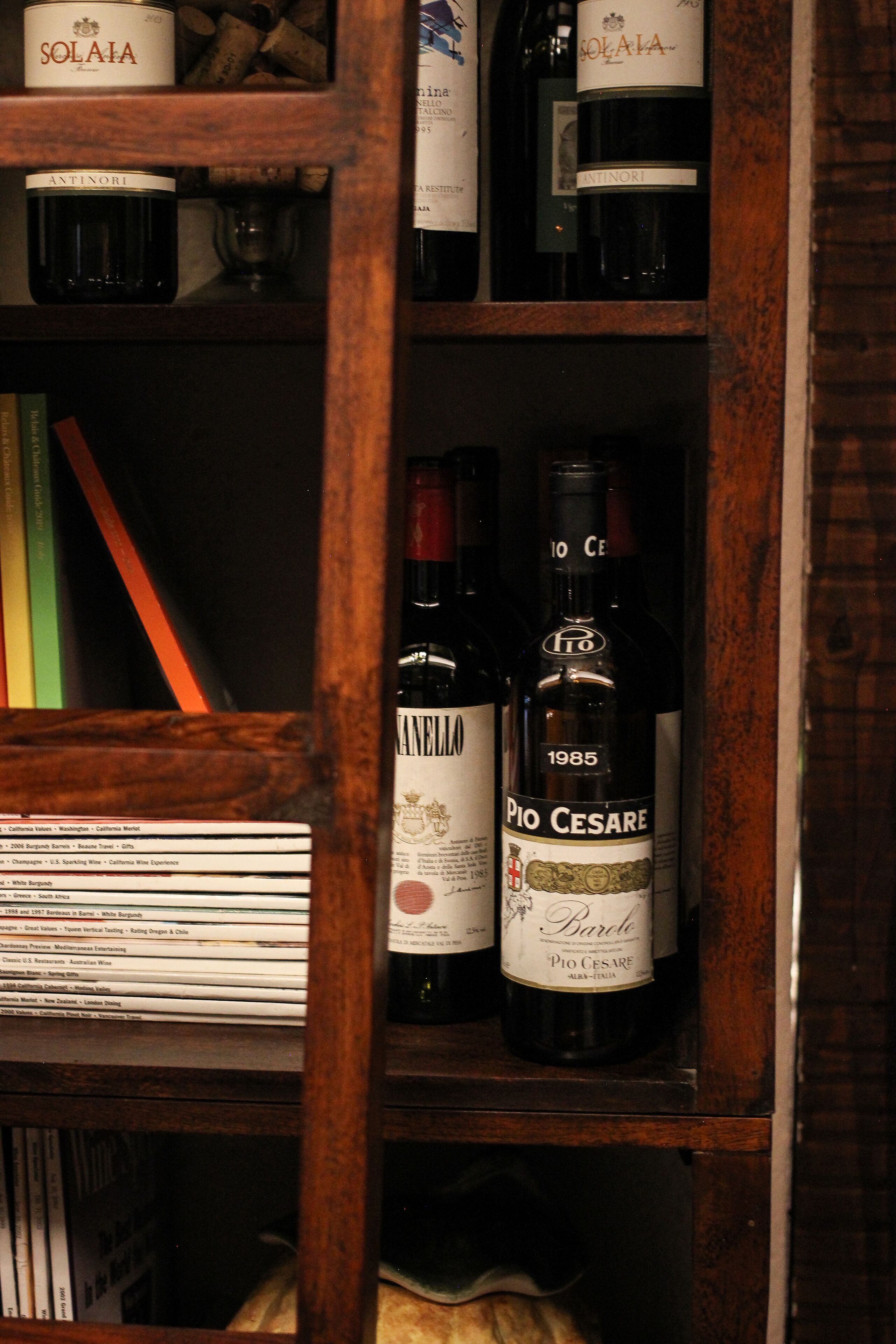 A wooden wine rack with bottles of Pio Cesare and other wines.