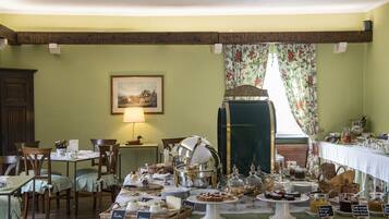 Un buffet de petit-déjeuner proposant divers plats et une table entourée de chaises.
