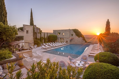 Una piscina al aire libre de temporada, sombrillas, tumbonas. Le Vieux Castillon