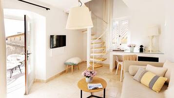 A modern living room with a sofa, coffee table, and a staircase.