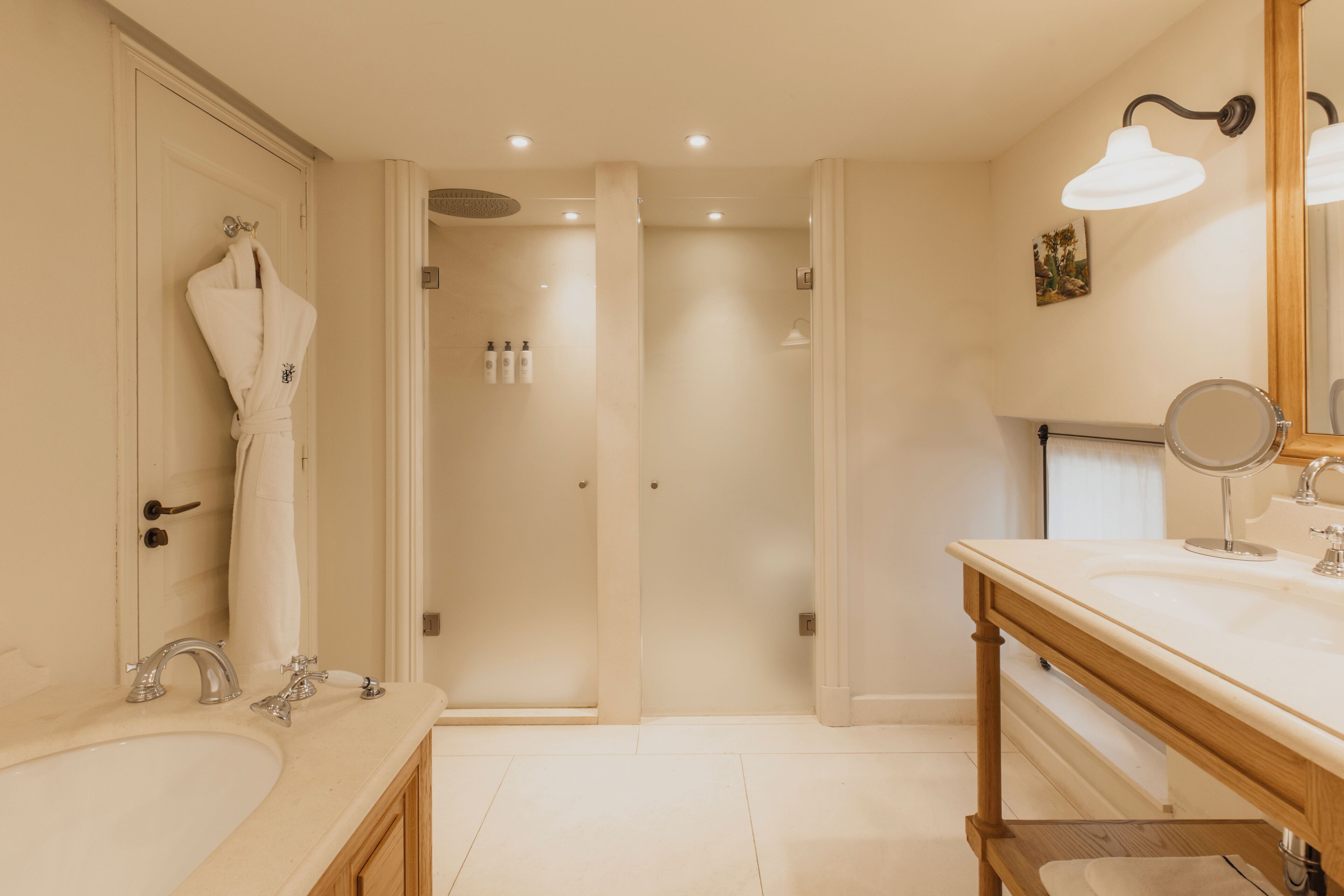 A modern bathroom with a double sink, a large mirror, and a shower area.