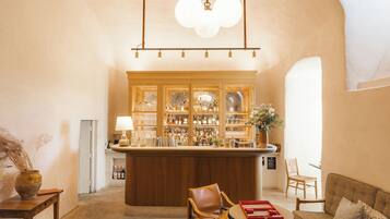 A bar area with wooden cabinets, a round table, and a sofa.