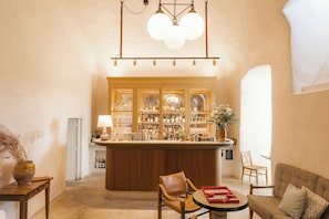 A bar area with wooden cabinets, a round table, and a sofa.