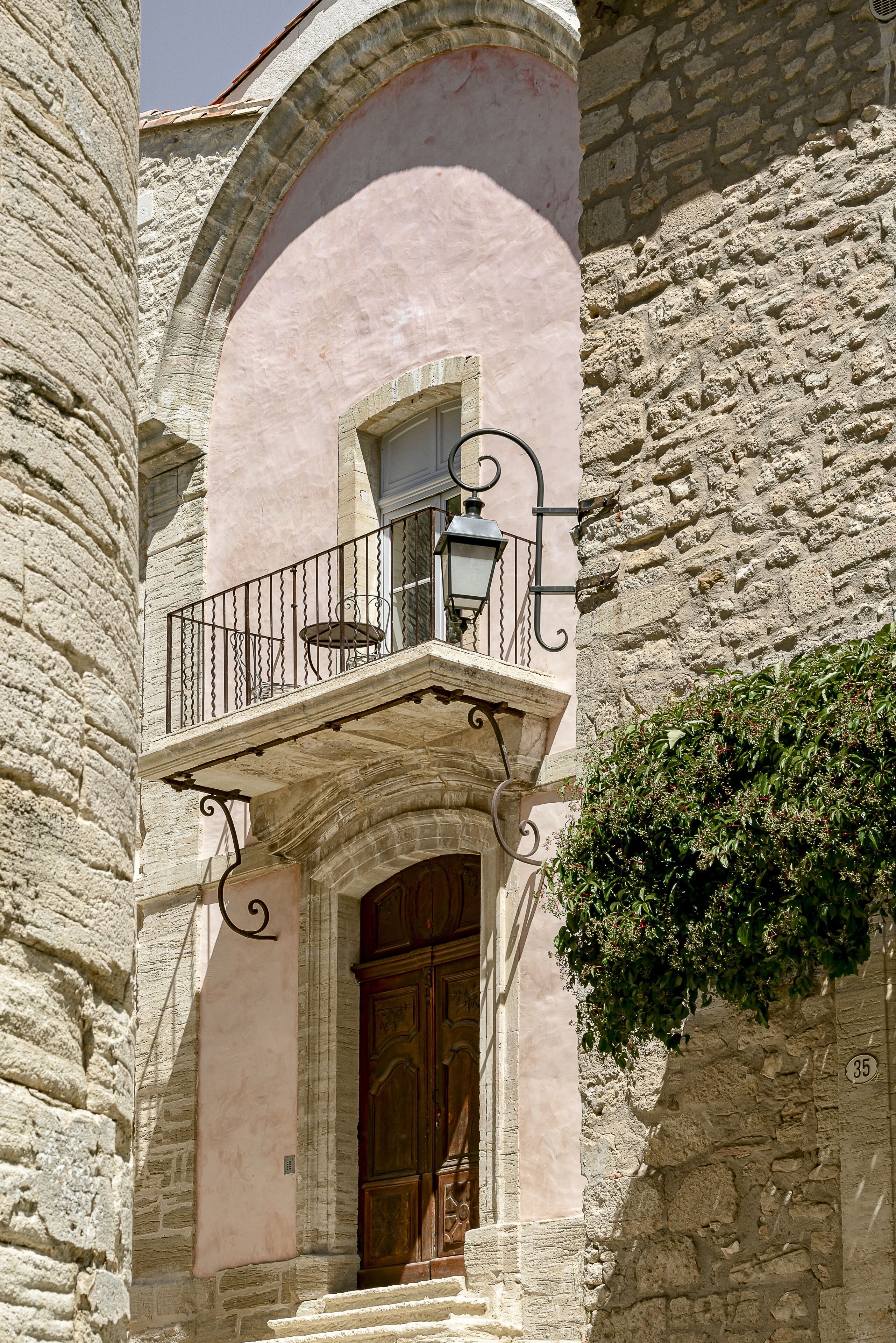 Un bâtiment en pierre doté d’un balcon, d’une porte en bois et du numéro « 35 » peint sur le mur.