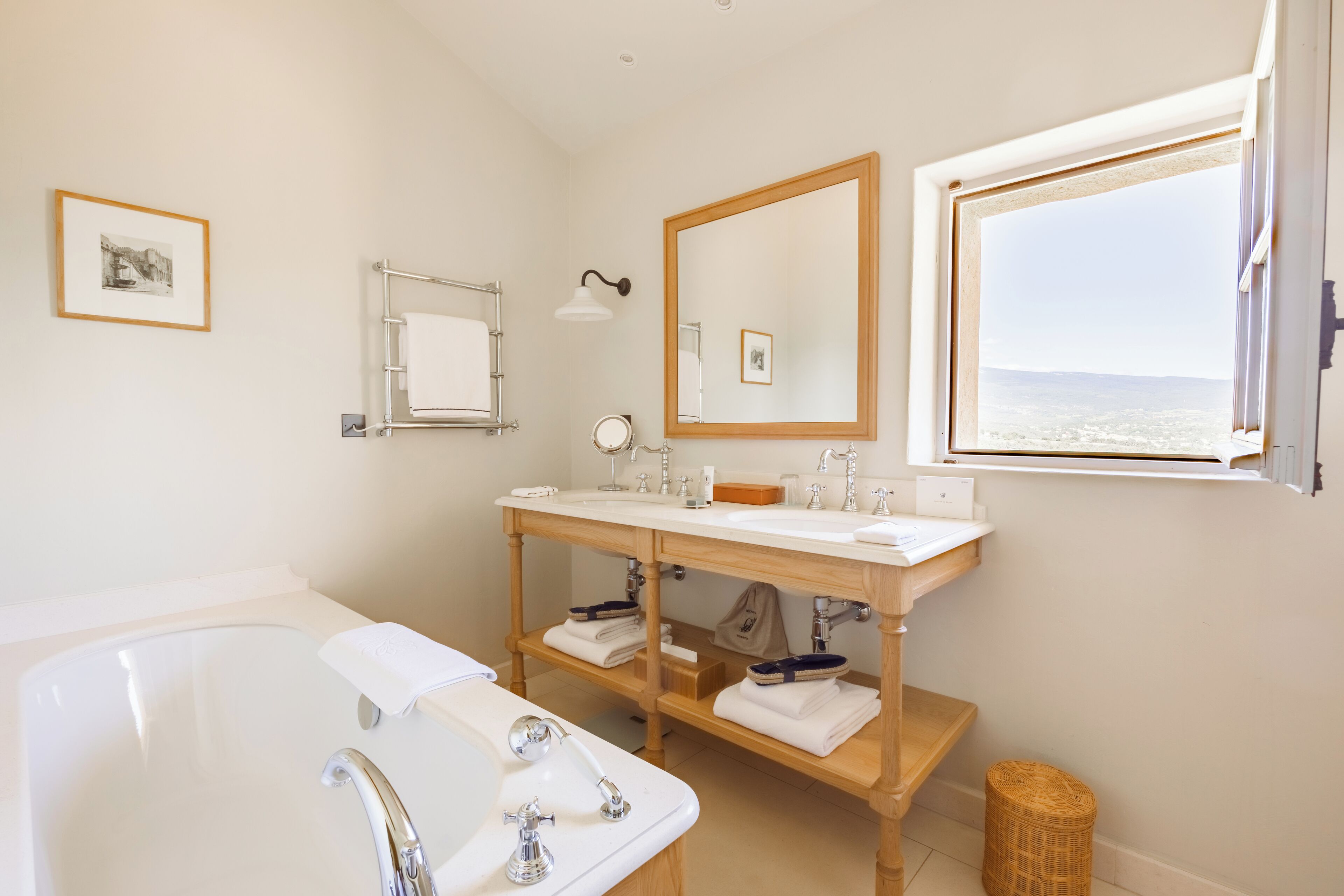 Un baño moderno con lavamanos doble, un espejo grande y una bañera.
