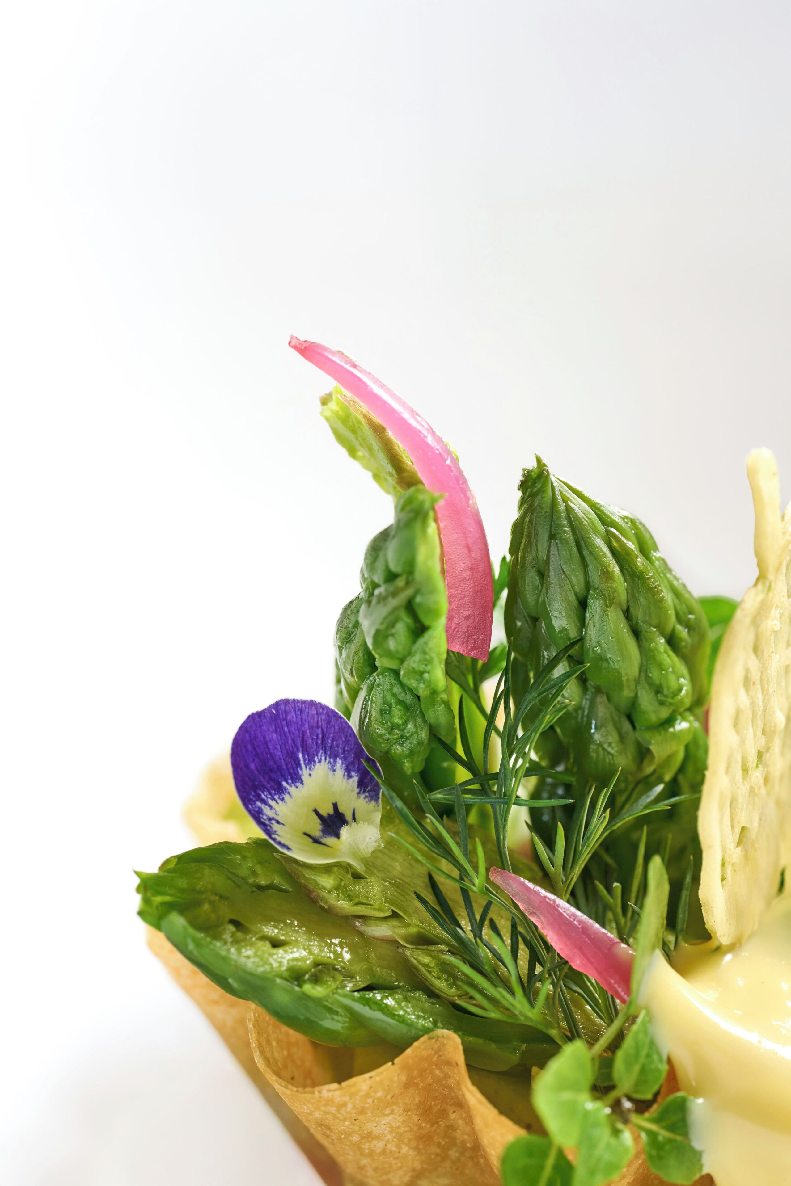 A close-up of a food dish with various vegetables and a piece of bread.