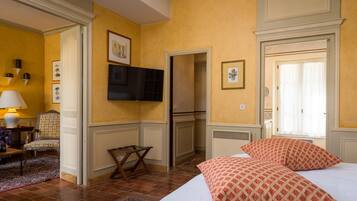 A hotel room with a bed, a television, a small table, and a chair.