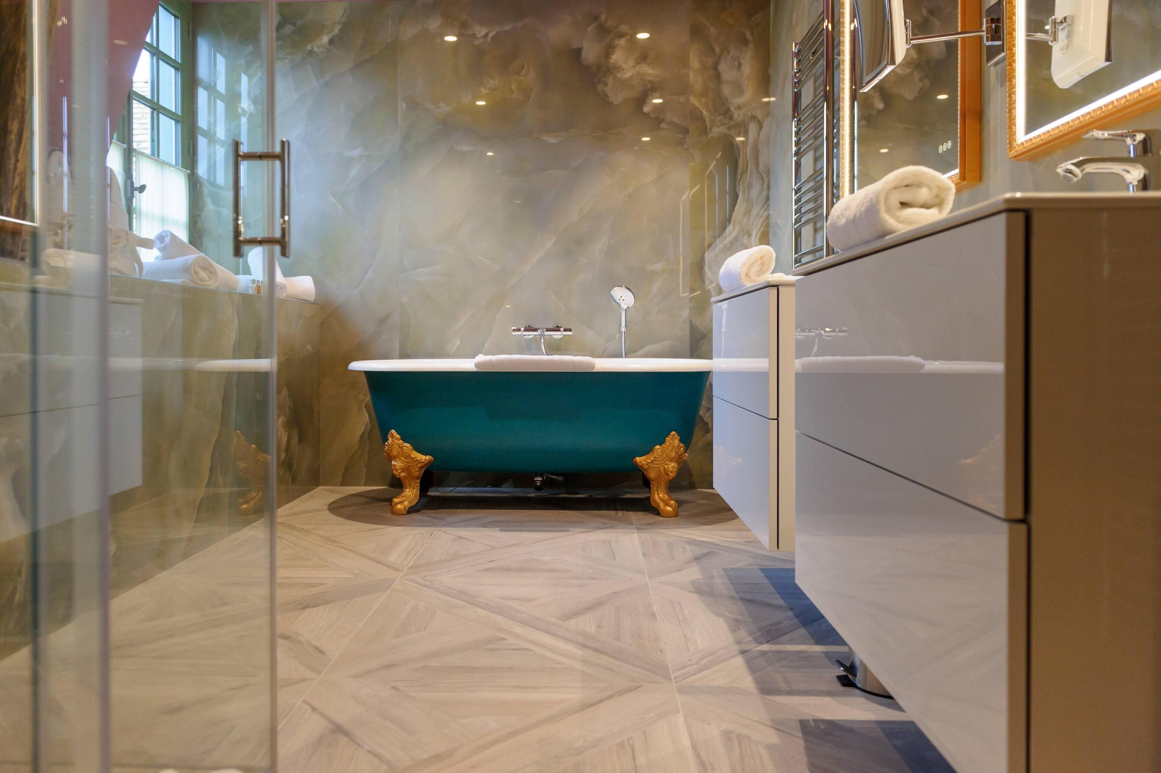 A bathroom with a freestanding bathtub, a glass shower enclosure, and a marble floor.