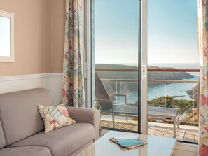 Suite, vista al mar | Área de sala de estar | Televisión de pantalla plana 