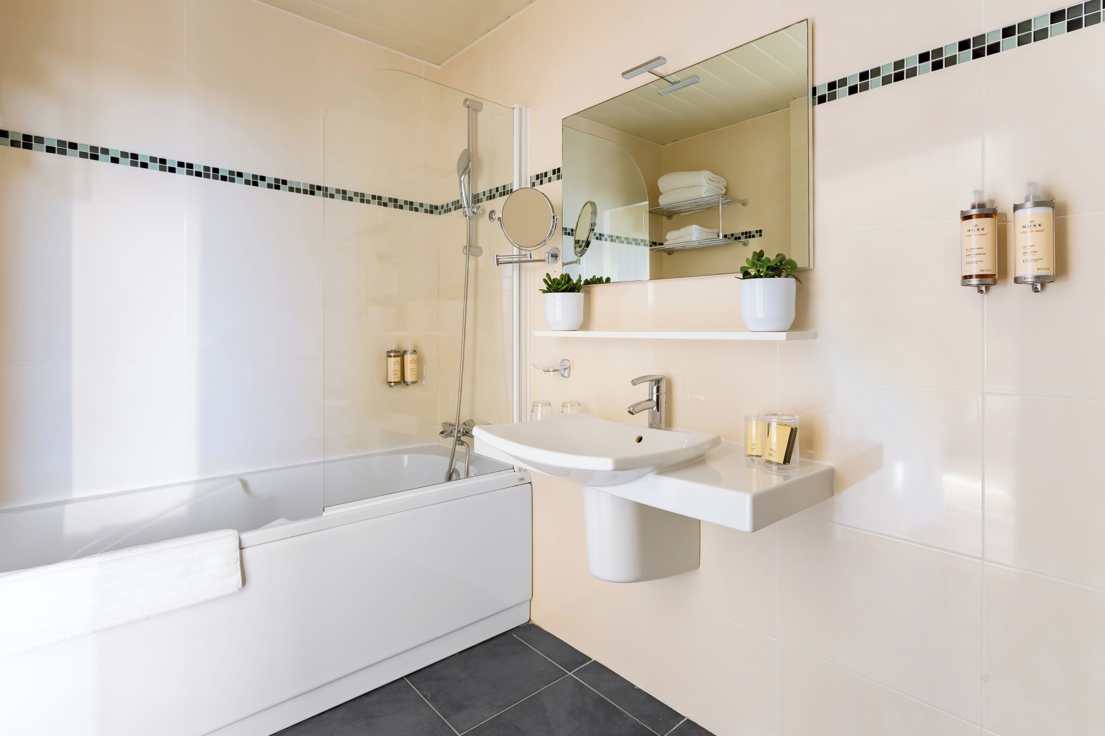 Un baño moderno con bañera, lavabo y espejo.