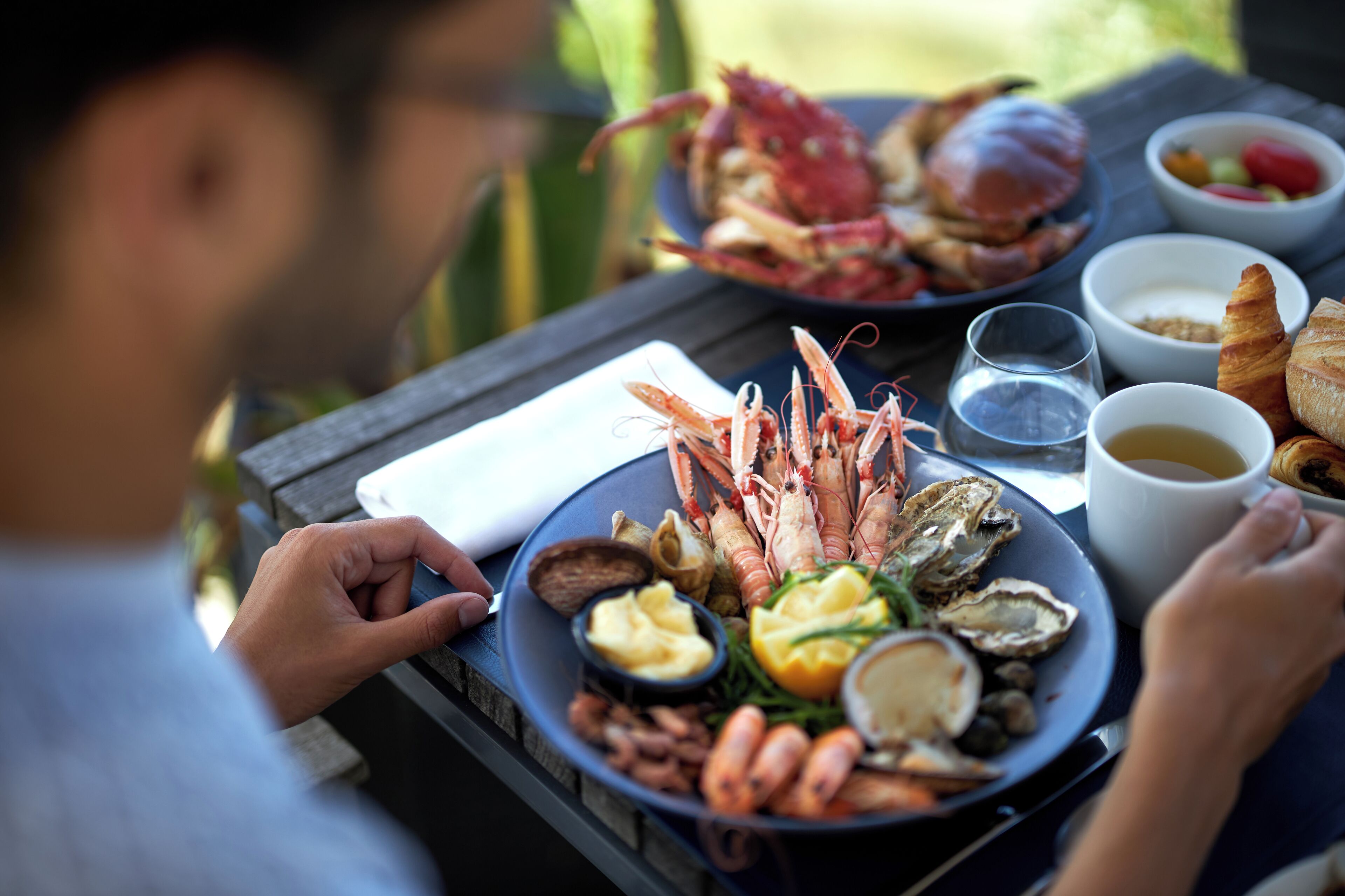 A dining table with seafood, bread, and beverages.