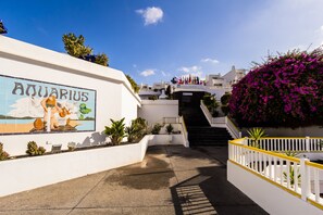 A staircase leading to a building with a sign reading "Aquarius" and a mural of a woman holding a fish.