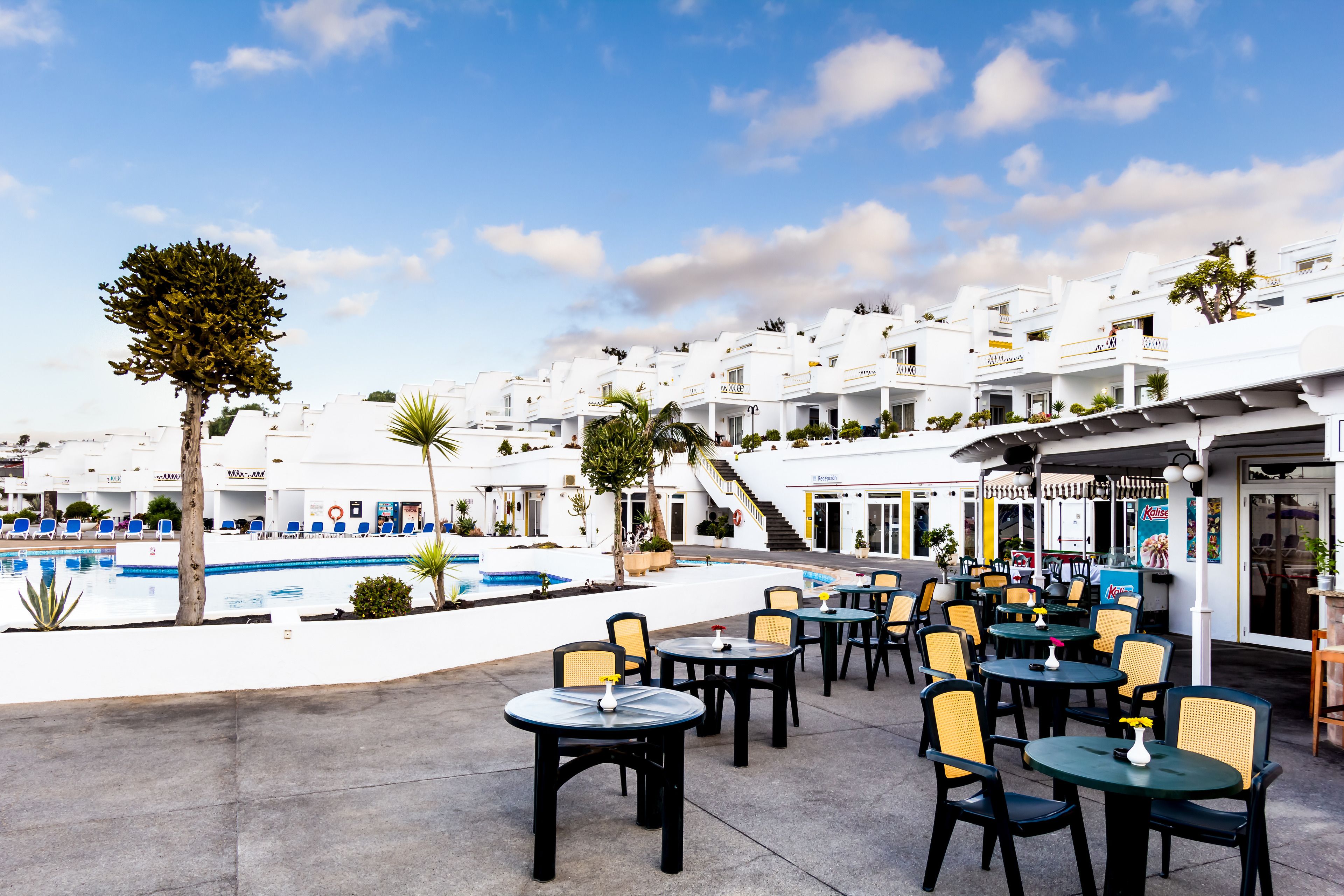 A resort with outdoor seating and a swimming pool.