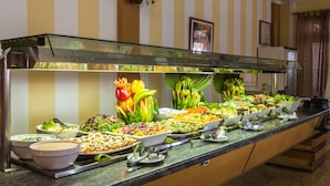 Un bufé con diversas opciones de comida y un expositor de vidrio.