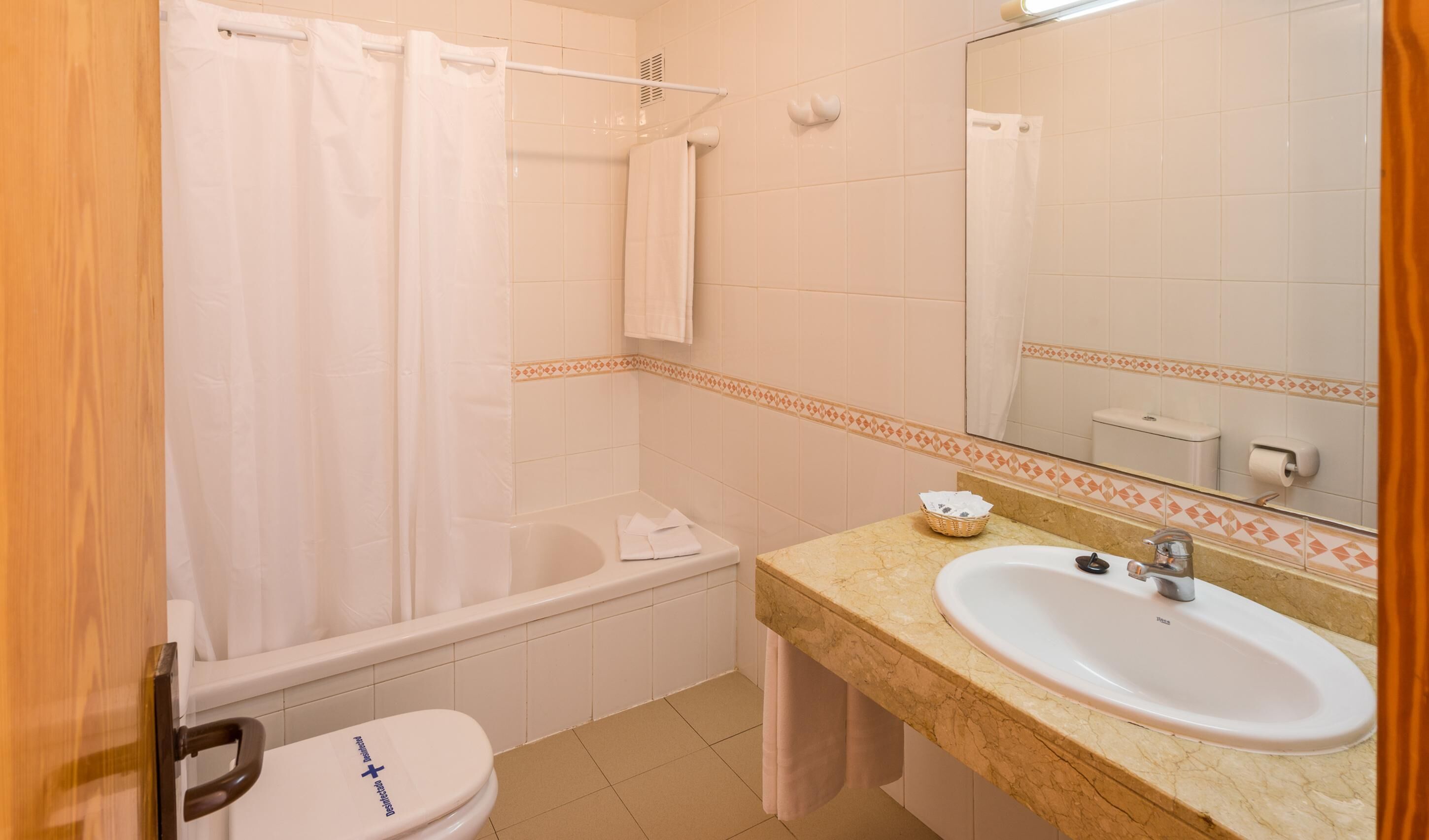Un bagno con vasca, servizi igienici e lavandino.
