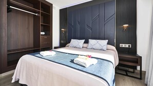 A hotel room with a bed, a wardrobe, and a nightstand. - Hotel BelleVue Club (Alcúdia)