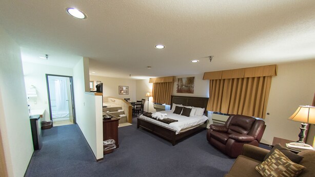 Una habitación de hotel con cama, escritorio, silla y sofá.