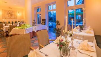 A restaurant with multiple tables set for dining, featuring a mix of indoor and outdoor seating.