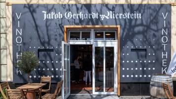 Eine Gebäudefassade mit der Aufschrift 'Jablon Gerhardt Bierstein' und einem Weinfass davor.