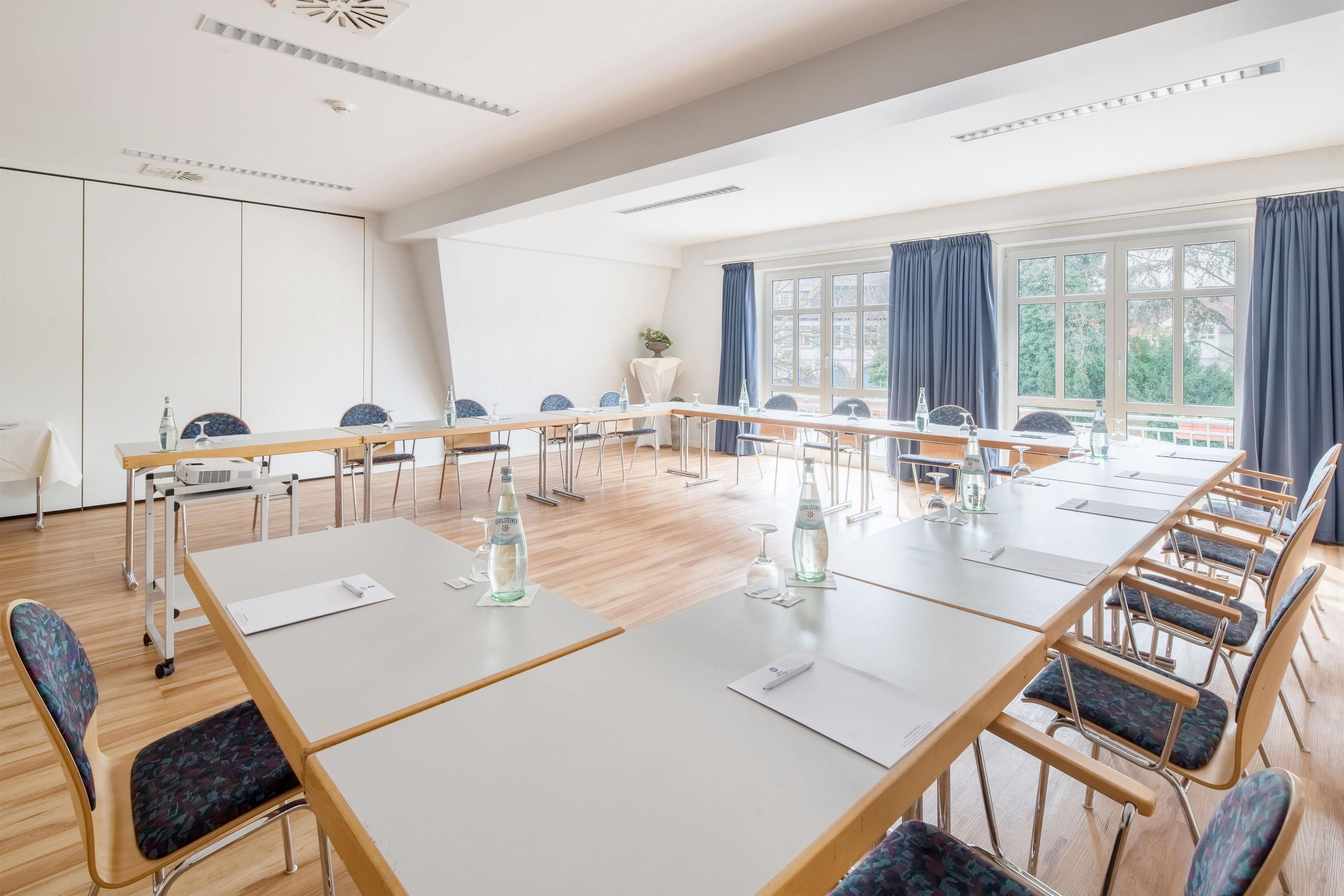 A conference room with a long table, chairs, and a projector.