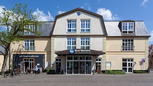 Un hôtel arborant une enseigne « Best Western » bien visible, présentant un style architectural traditionnel et doté d’une zone d’entrée pavée.