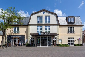 Un hôtel arborant une enseigne « Best Western » bien visible, présentant un style architectural traditionnel et doté d’une zone d’entrée pavée.