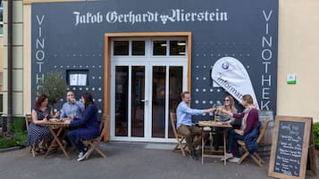 An outdoor seating area in front of a restaurant with a sign that reads 'Jahob Gerhardt Bierstein.'