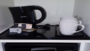 Une machine à café, une tasse et un clavier à code sur un comptoir.