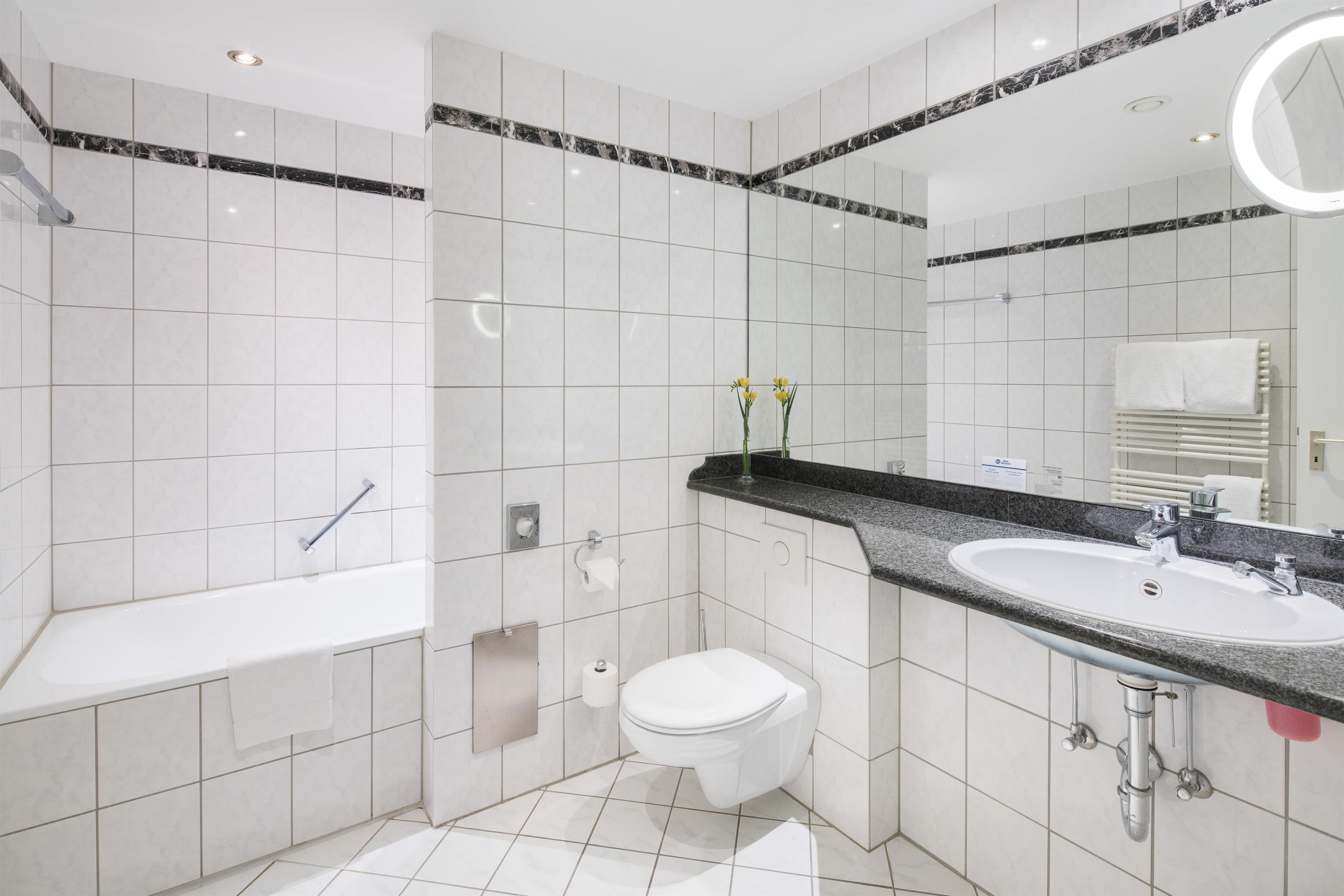 Un baño moderno con bañera, inodoro y lavabo.