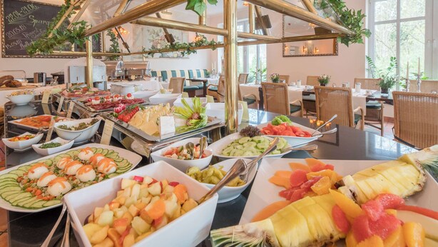 Un buffet proposant une variété d’aliments, notamment des fruits, des légumes et des fromages.