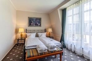 A hotel room with a bed, two bedside lamps, a painting on the wall, and a window with curtains. - Best Western Wein-Und Parkhotel Nierstein (Nierstein)