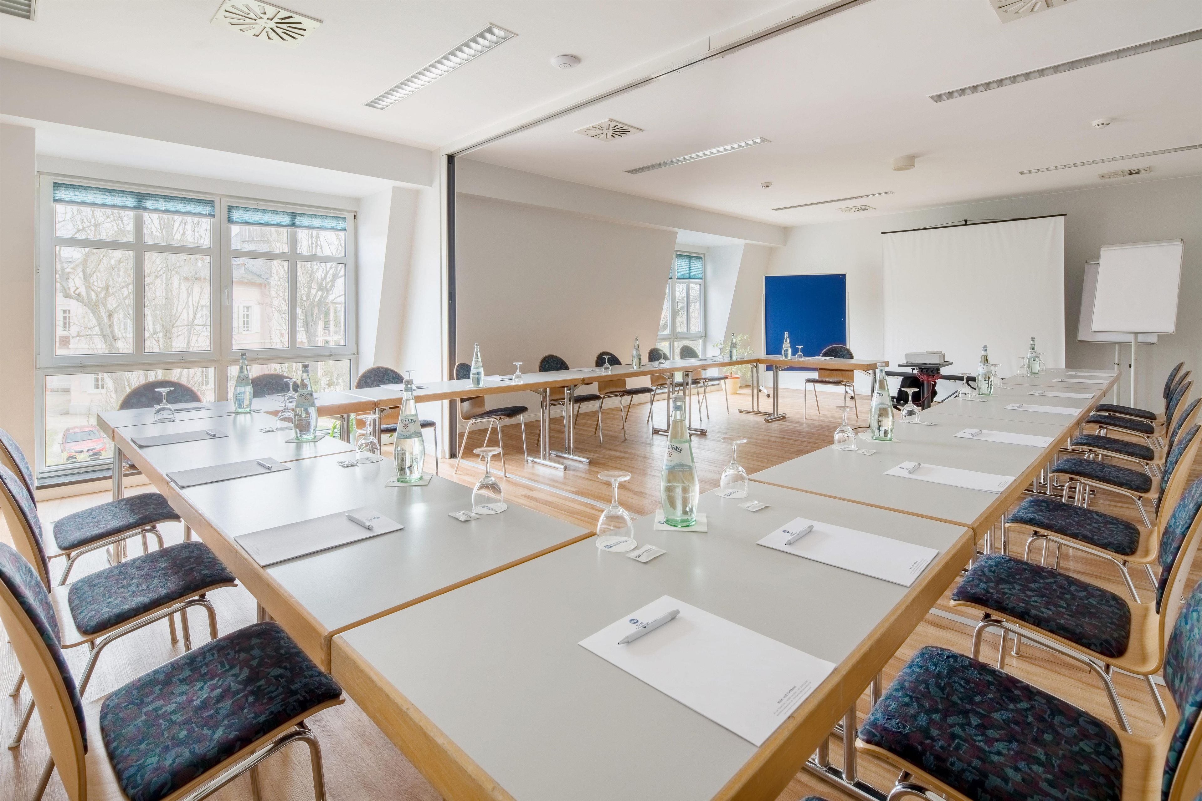 A conference room with a long table, chairs, and a whiteboard.