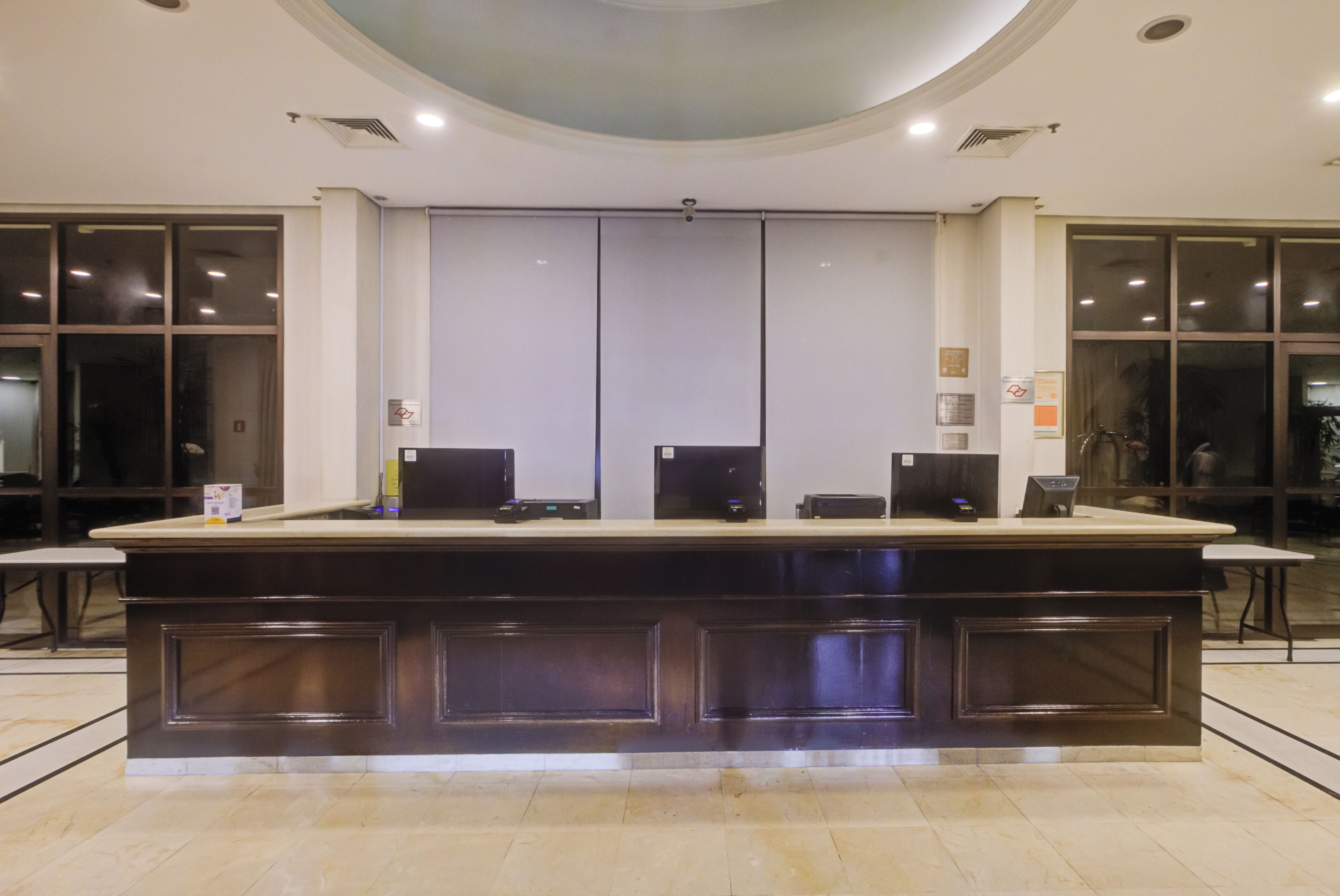 A reception desk with a counter, a large window, and a door.